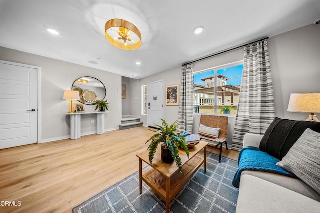 living area featuring recessed lighting, baseboards, stairway, and wood finished floors