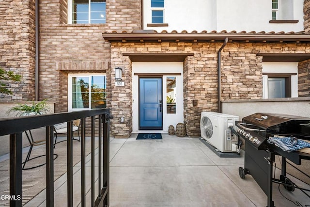 entrance to property with stone siding and ac unit