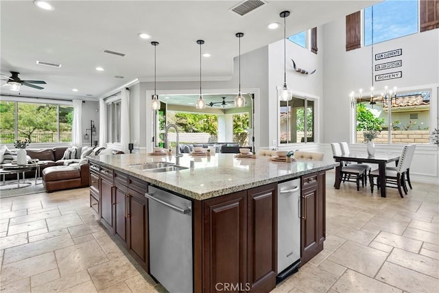 kitchen with stone tile flooring, open floor plan, a sink, and visible vents