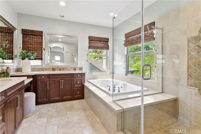 full bath with a shower stall, recessed lighting, vanity, and a garden tub