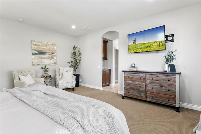 carpeted bedroom featuring recessed lighting, arched walkways, visible vents, and baseboards