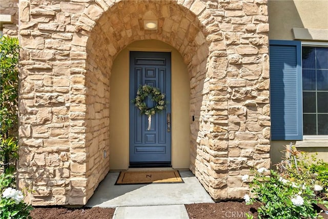 entrance to property featuring stone siding