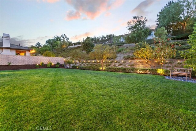 yard at dusk featuring fence