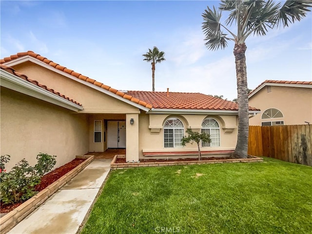 view of front of house with fence, stucco siding, and a front yard