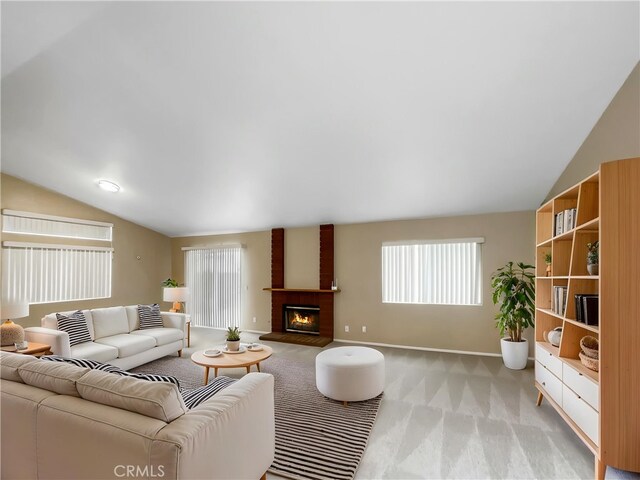 living area featuring a brick fireplace, vaulted ceiling, light carpet, and baseboards