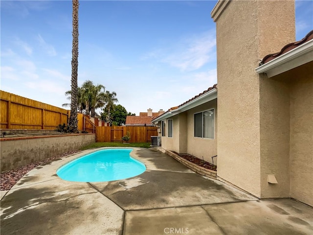 view of pool featuring a patio, central air condition unit, a fenced in pool, and a fenced backyard