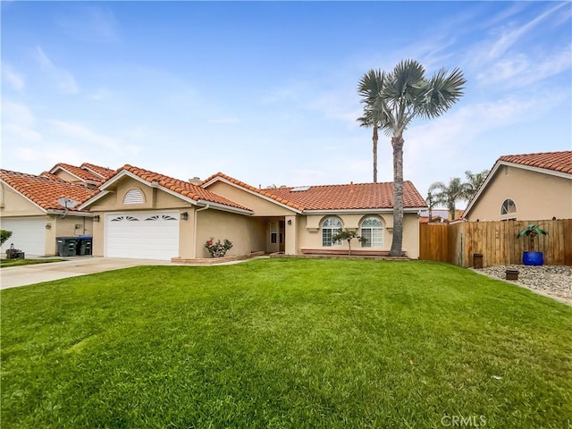 mediterranean / spanish house with a front yard, a garage, a tiled roof, stucco siding, and fence