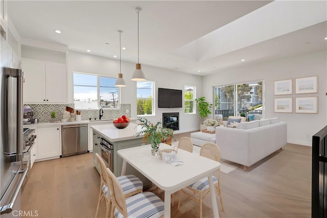 2100 Carnegie Ln, Redondo Beach, CA 90278 - kitchen featuring appliances with stainless steel finishes, recessed lighting, light wood-style flooring, backsplash, and open floor plan