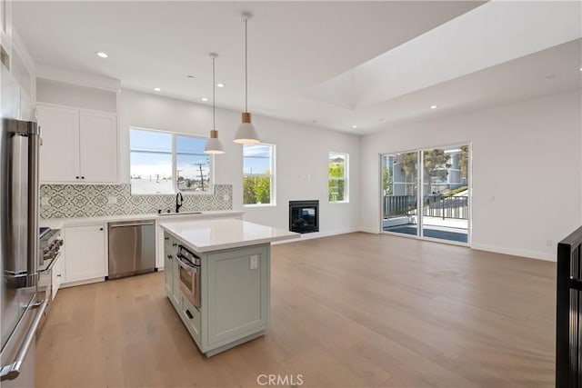 2100 Carnegie Ln, Redondo Beach, CA 90278 - kitchen with stainless steel appliances, recessed lighting, light wood-style floors, backsplash, and a center island