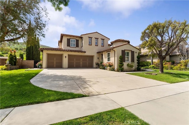 mediterranean / spanish-style house with a tiled roof, stucco siding, a front yard, an attached garage, and concrete driveway