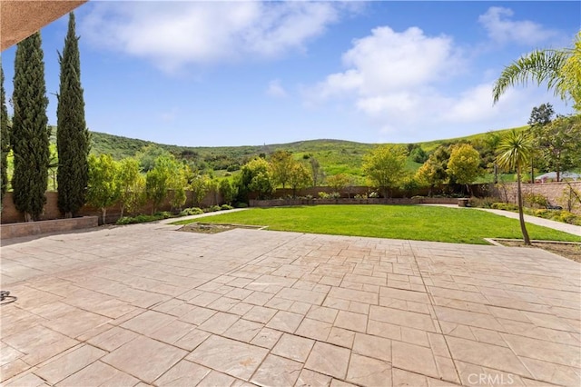 view of patio with a mountain view and fence