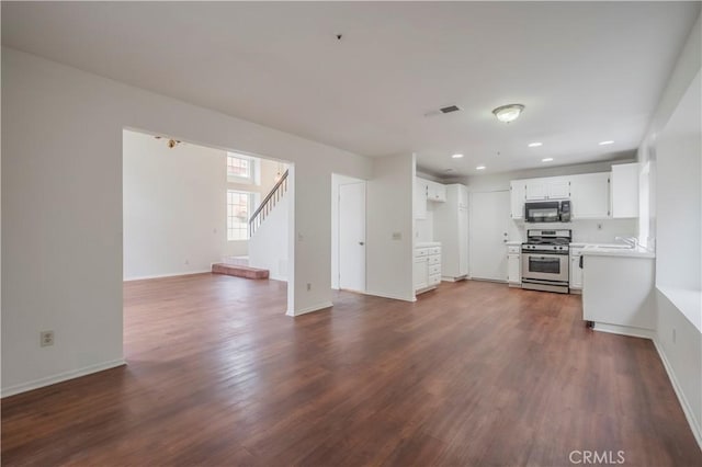 11962 Verona Dr, Fontana, CA 92337 - unfurnished living room featuring dark wood-style flooring, baseboards, recessed lighting, and stairway