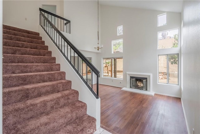 11962 Verona Dr, Fontana, CA 92337 - stairs with a healthy amount of sunlight, a high ceiling, baseboards, and wood finished floors