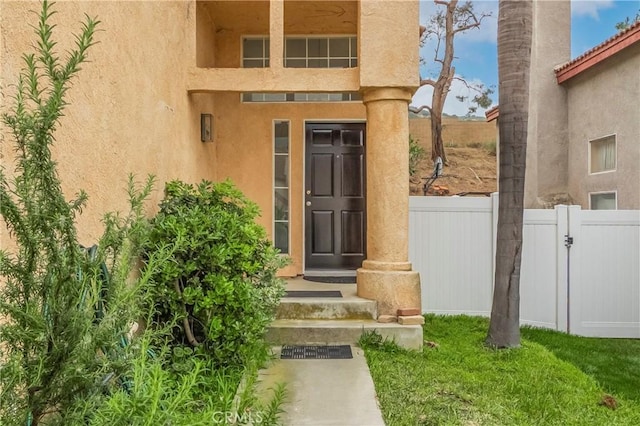 11962 Verona Dr, Fontana, CA 92337 - property entrance featuring stucco siding, fence, and a gate