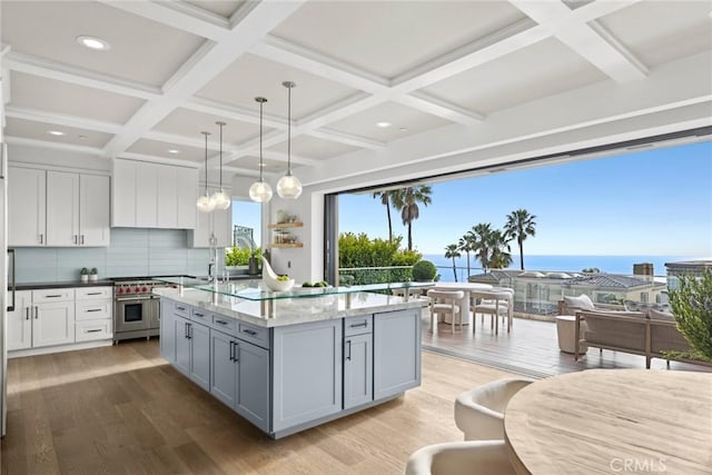 739 Marlin, Laguna Beach, CA 92651 - kitchen with an island with sink, light wood-style flooring, tasteful backsplash, high end stainless steel range oven, and coffered ceiling