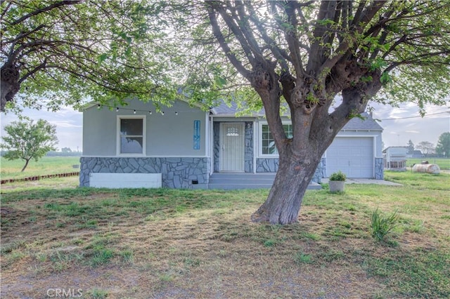 1124 S Moffett Rd, Turlock, CA 95380 - view of property hidden behind natural elements featuring a garage, stucco siding, stone siding, and a front lawn