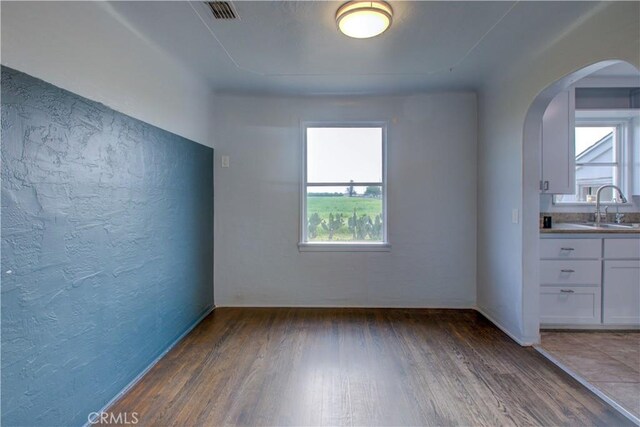 1124 S Moffett Rd, Turlock, CA 95380 - interior space featuring a wealth of natural light, arched walkways, dark wood-type flooring, and a sink