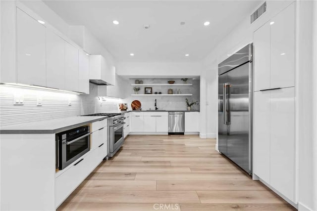 9027 Wonderland Ave, Los Angeles, CA 90046 - kitchen featuring high quality appliances, a sink, open shelves, recessed lighting, and white cabinetry