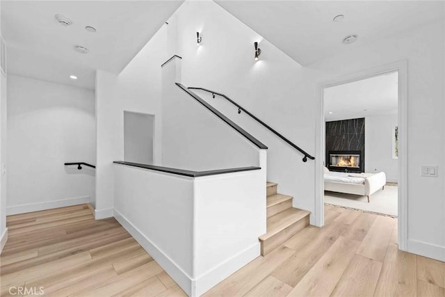 9027 Wonderland Ave, Los Angeles, CA 90046 - stairs featuring wood finished floors, a fireplace, baseboards, and recessed lighting