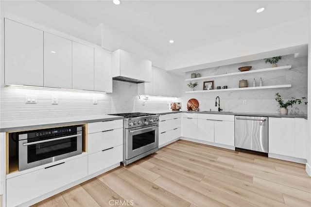 9027 Wonderland Ave, Los Angeles, CA 90046 - kitchen featuring stainless steel appliances, a sink, open shelves, modern cabinets, and decorative backsplash