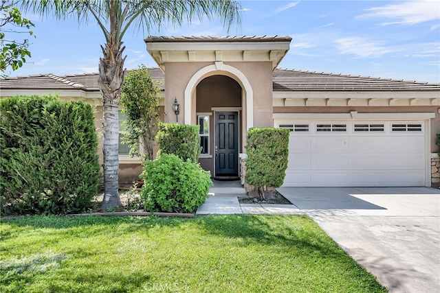 16569 Sugar Ln, Fontana, CA 92337 - view of front facade featuring an attached garage, driveway, a front lawn, and a tile roof