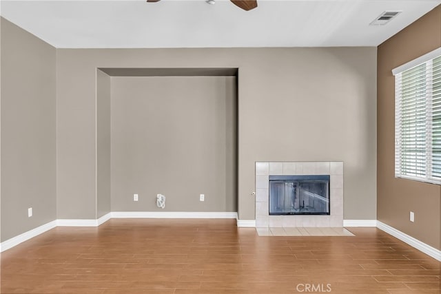 16569 Sugar Ln, Fontana, CA 92337 - unfurnished living room with a ceiling fan, wood finished floors, healthy amount of natural light, and a tile fireplace