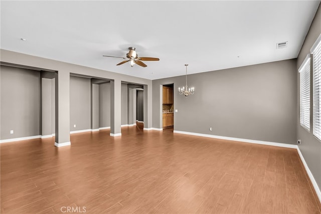 16569 Sugar Ln, Fontana, CA 92337 - unfurnished living room with a ceiling fan, a chandelier, light wood-style floors, and baseboards