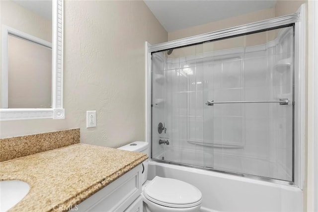 bathroom with toilet, a textured wall, vanity, and bath / shower combo with glass door