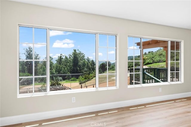 doorway to outside featuring baseboards and wood finished floors
