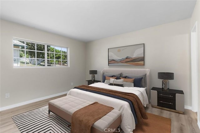 bedroom featuring baseboards and wood finished floors