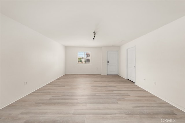 spare room with light wood finished floors and baseboards