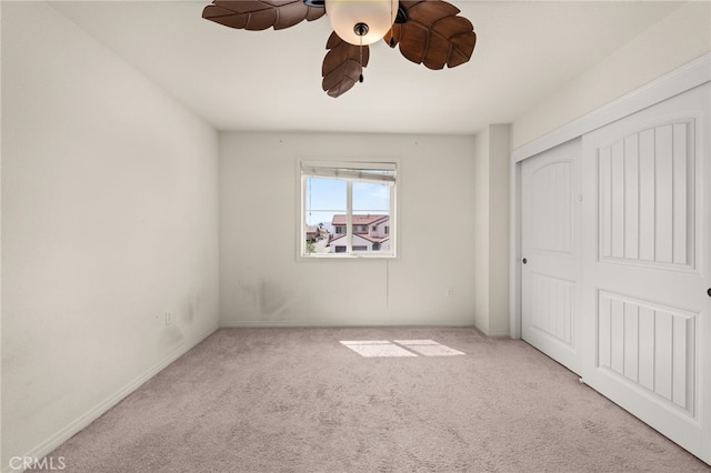unfurnished bedroom featuring carpet, a closet, and ceiling fan