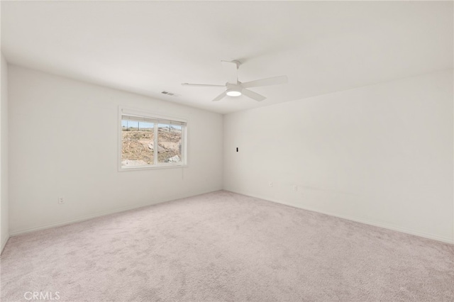 empty room featuring light carpet, baseboards, visible vents, and ceiling fan