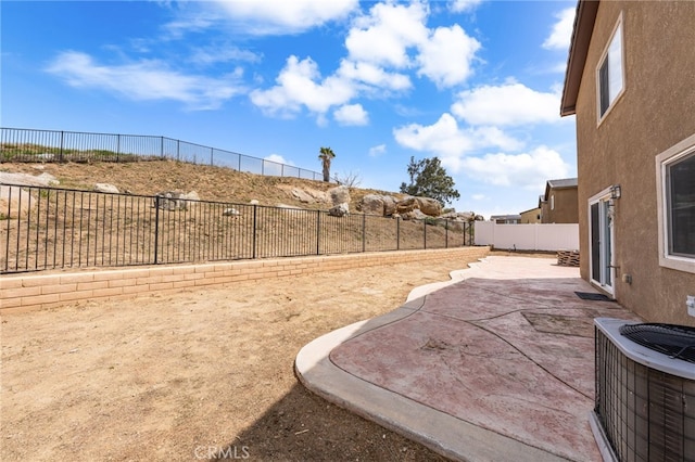 view of yard featuring a patio area, a fenced backyard, and central AC unit