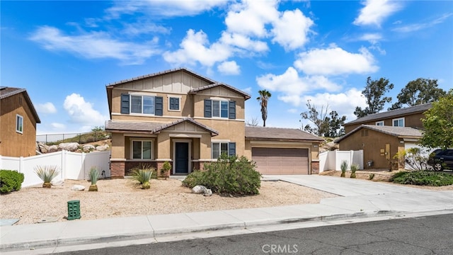 view of front of home with stucco siding, driveway, a garage, a tiled roof, and fence
