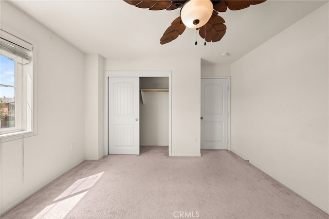 unfurnished bedroom with a closet, a ceiling fan, and light colored carpet