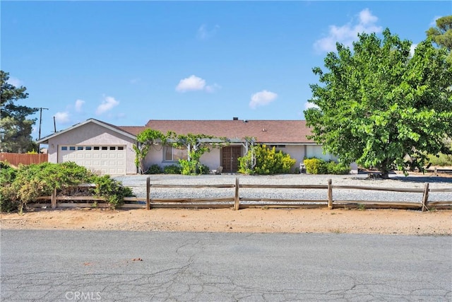 19891 Talihina Rd, Apple Valley, CA 92307 - ranch-style house with a fenced front yard, an attached garage, stucco siding, and driveway