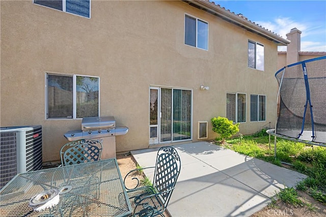 25382 Silverwood Ln, Menifee, CA 92584 - rear view of house featuring a trampoline, a patio area, stucco siding, central air condition unit, and outdoor dining space