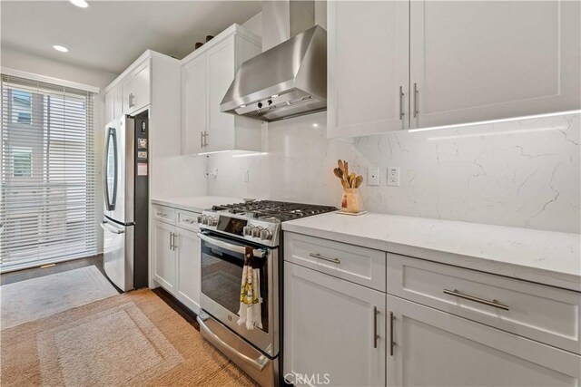 19533 Cardigan Dr, Northridge, CA 91324 - kitchen featuring tasteful backsplash, white cabinets, wall chimney range hood, appliances with stainless steel finishes, and recessed lighting
