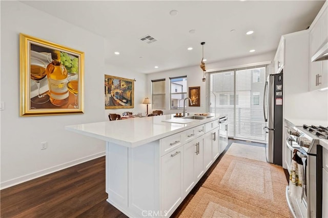 19533 Cardigan Dr, Northridge, CA 91324 - kitchen featuring light countertops, a kitchen island with sink, visible vents, stainless steel appliances, and a sink