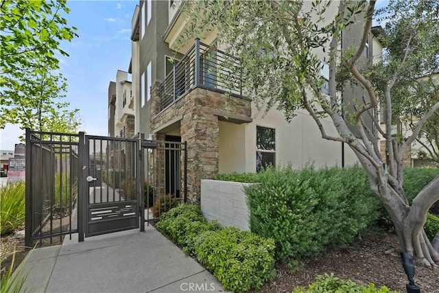 19533 Cardigan Dr, Northridge, CA 91324 - view of property exterior with fence, stone siding, a gate, and stucco siding