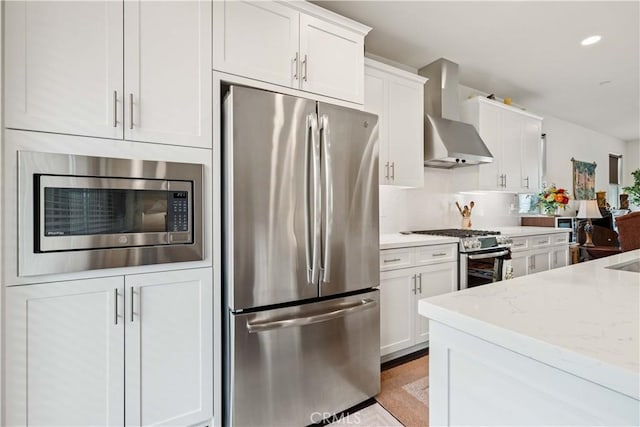 19533 Cardigan Dr, Northridge, CA 91324 - kitchen with recessed lighting, white cabinetry, light stone countertops, wall chimney exhaust hood, and stainless steel appliances