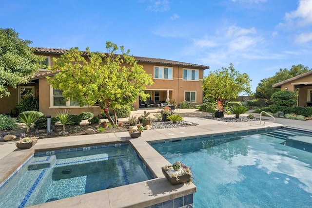 outdoor pool featuring a patio and an in ground hot tub
