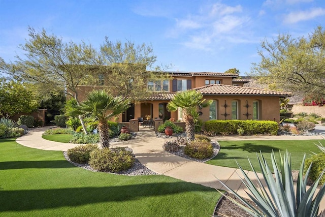 rear view of property featuring a yard, solar panels, a tile roof, and stucco siding