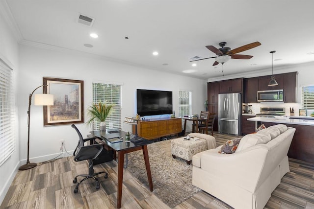 living area with visible vents, ornamental molding, wood finished floors, recessed lighting, and a ceiling fan