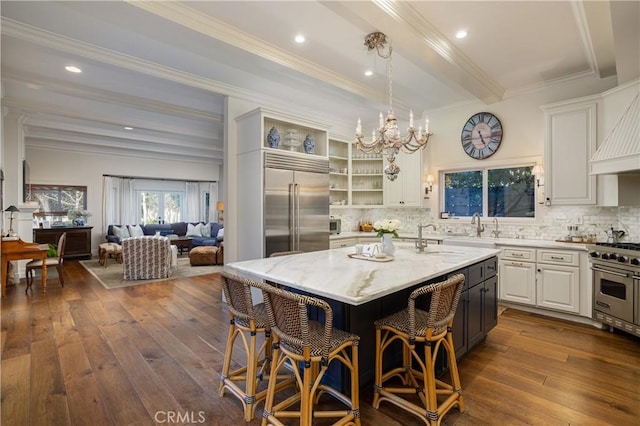 kitchen with high end appliances, decorative backsplash, dark wood finished floors, and light stone countertops