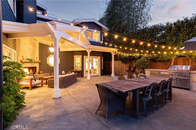 view of patio with french doors, an outdoor living space with a fireplace, fence, and outdoor dining space