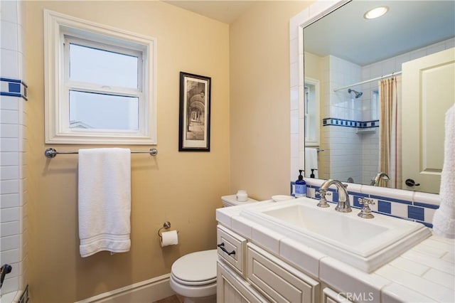 full bathroom with toilet, a shower with curtain, baseboards, and vanity