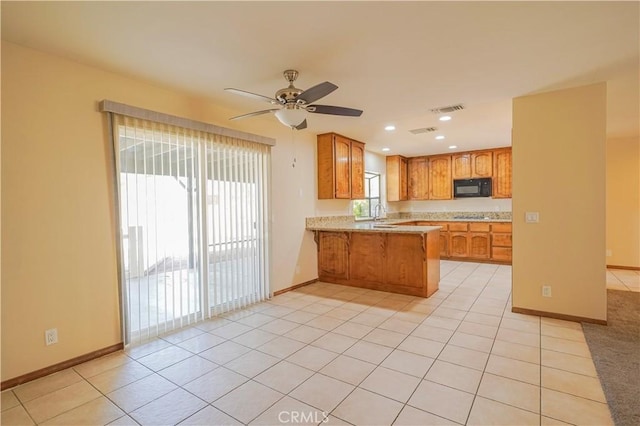 15084 Tacony Rd, Apple Valley, CA 92307 - kitchen featuring brown cabinets, visible vents, black microwave, a peninsula, and ceiling fan