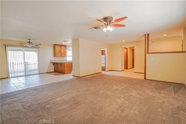 15084 Tacony Rd, Apple Valley, CA 92307 - unfurnished living room featuring light tile patterned floors, visible vents, light colored carpet, and ceiling fan